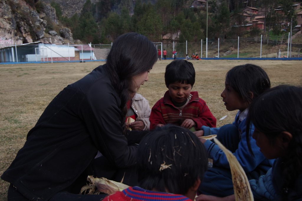 Rachel teaching the kids how to make husk dolls