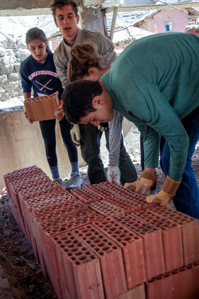 moving bricks to clear the area to build the walls