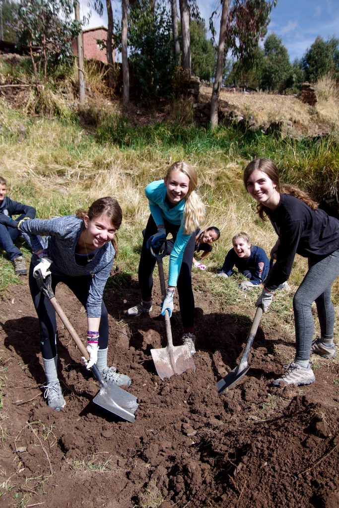Sofia, Grace, and Chelsea clearing the land for adobe